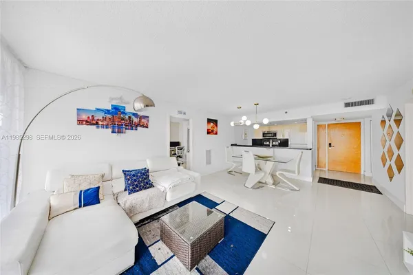 a living room with furniture and a dining table with kitchen view