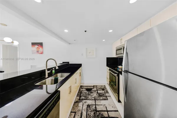 a kitchen with granite countertop a stove and a refrigerator