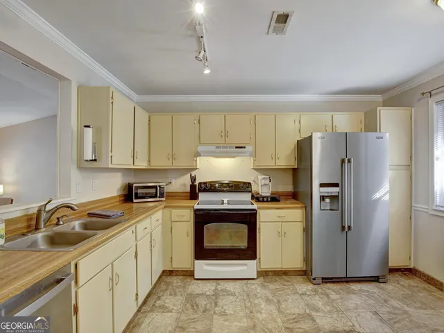 a kitchen with a stove sink and refrigerator