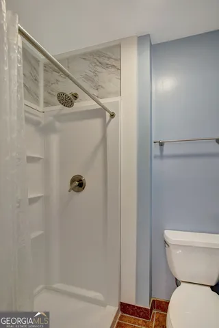 a bathroom with a toilet and a shower