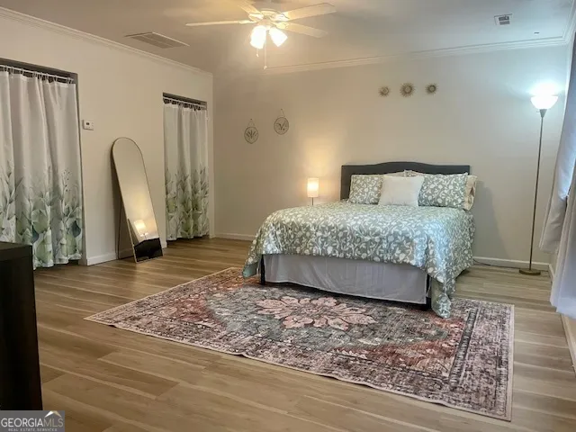 a bedroom with a bed a rug and wooden floor