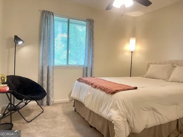 a bedroom with a bed a chair and a chandelier