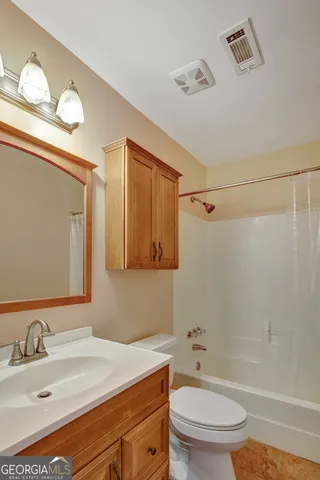 a bathroom with a granite countertop sink toilet a mirror and shower