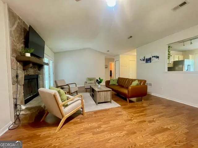 a living room with furniture a fireplace and a flat screen tv
