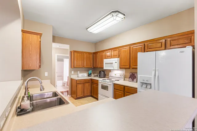 a kitchen with granite countertop a sink stainless steel appliances and cabinets