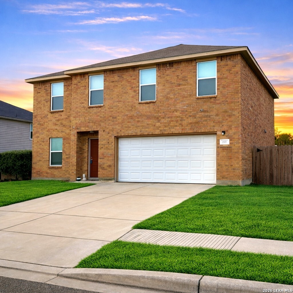 a front view of a house with a yard and garage