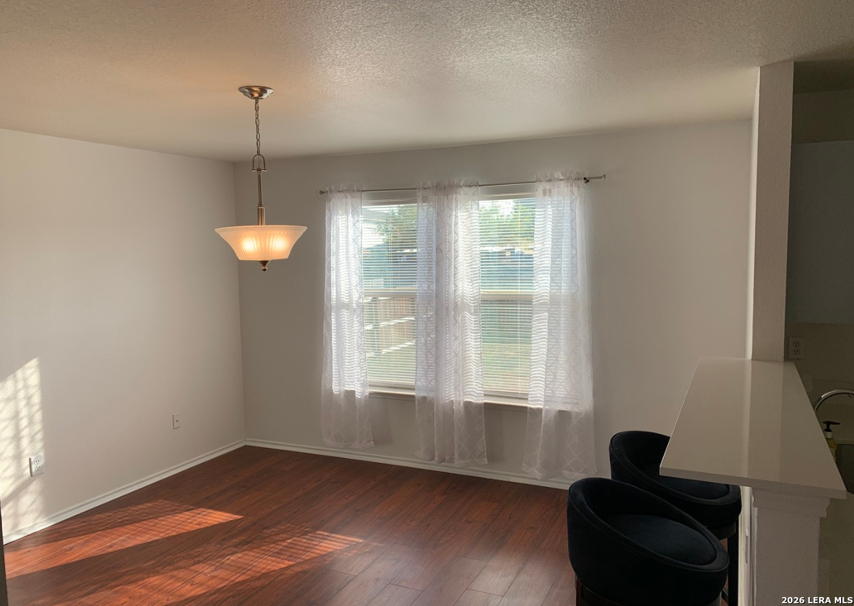 9818 Copper Elm Converse, TX 78109 - Photo 6 of 11 a view of an empty room with wooden floor and a window