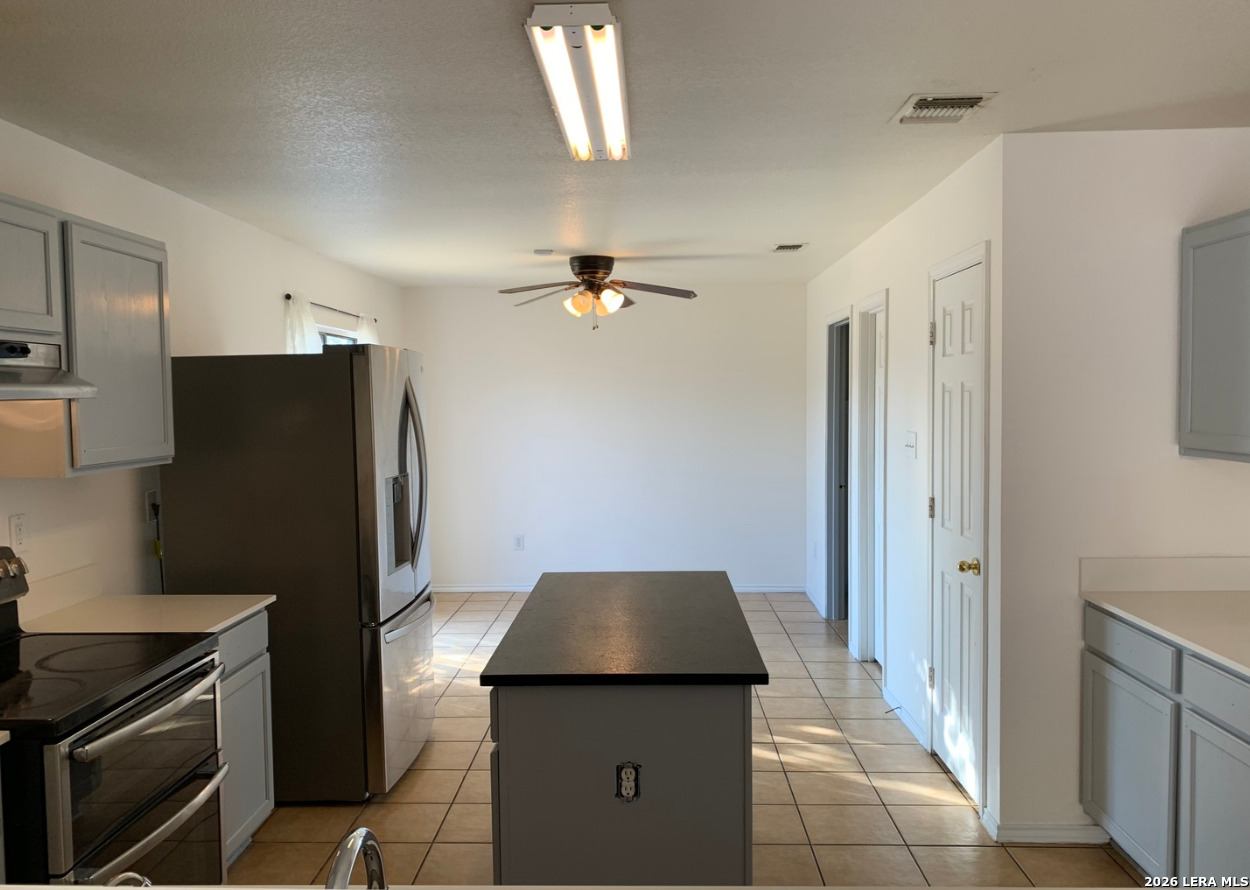 9818 Copper Elm Converse, TX 78109 - Photo 7 of 11 a kitchen with a refrigerator and a stove top oven
