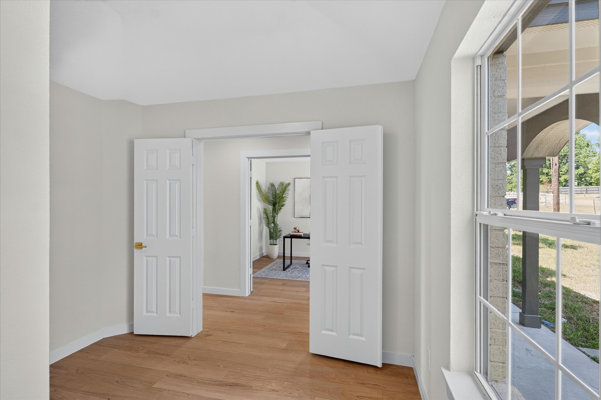 258 Pine View Loop Bastrop, TX 78602 - Photo 12 of 40 Natural light illuminates hardwood floors, offering a serene view of the surrounding landscape through a well-framed window.