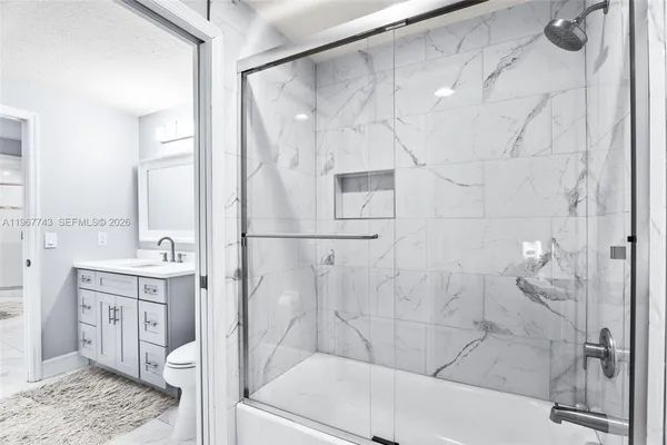 a bathroom with a sink mirror and a shower