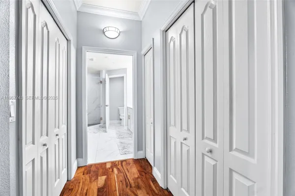 a view of a hallway with wooden floor and entryway