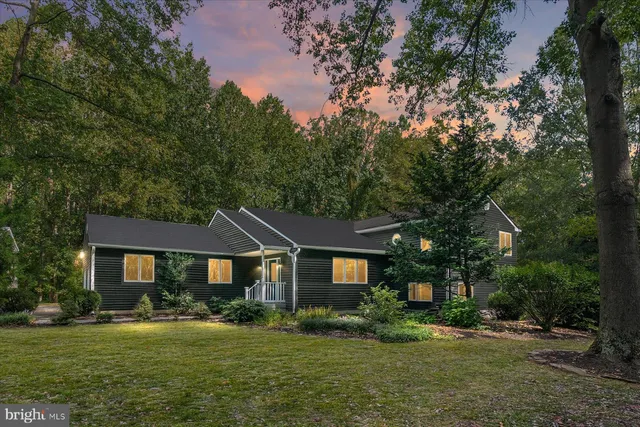 a front view of a house with a yard and trees