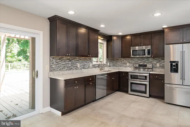 a kitchen with kitchen island granite countertop stainless steel appliances and cabinets