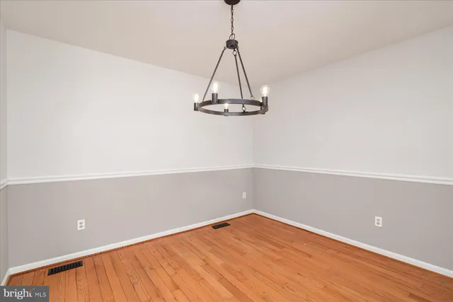a view of a room with wooden floor and white walls
