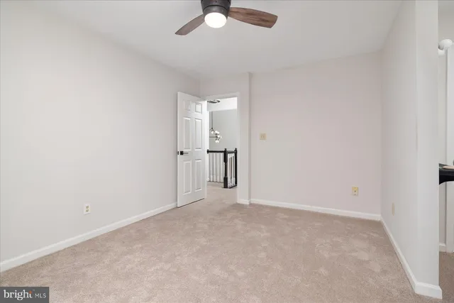 an empty room with a ceiling fan and a window