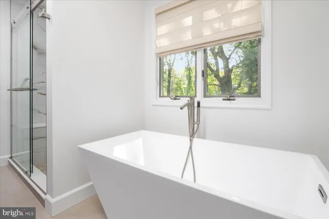 a white bath tub sitting in a bathroom next to a window