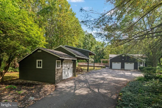 a front view of a house with a garden and trees