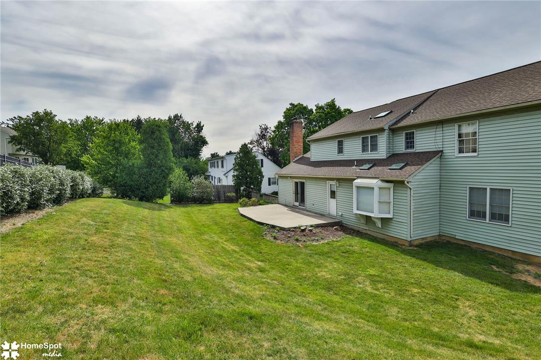 4059 Wedgewood Road Allentown, PA 18104 - Photo 70 of 72 A spacious backyard with mature trees and a concrete patio, perfect for outdoor living.