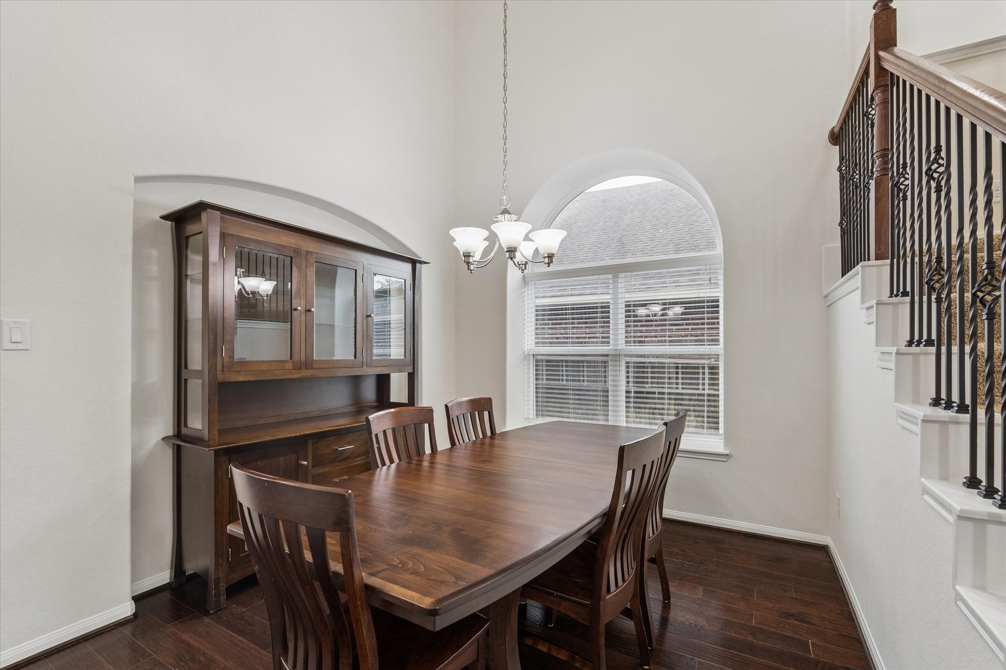 7015 Riata Hills Lane Spring, TX 77379 - Photo 6 of 33 The dining area features a beautiful window and high ceilings that create a bright, airy feel. It’s a warm and inviting space, perfect for enjoying meals with family and loved ones, enhanced by beautiful wood flooring.