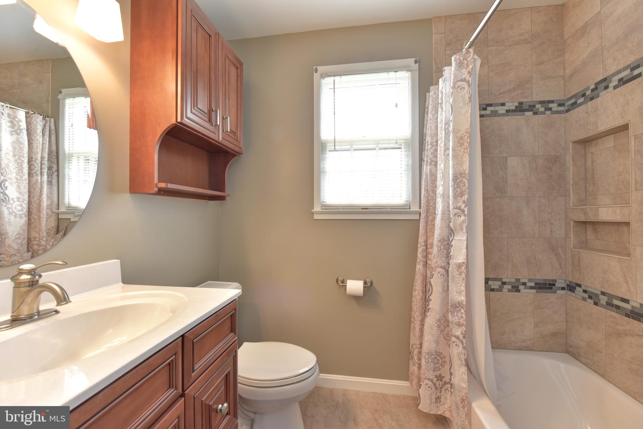 8021 Ellet Road Springfield, VA 22151 - Photo 17 of 53 a bathroom with a sink toilet a mirror and shower