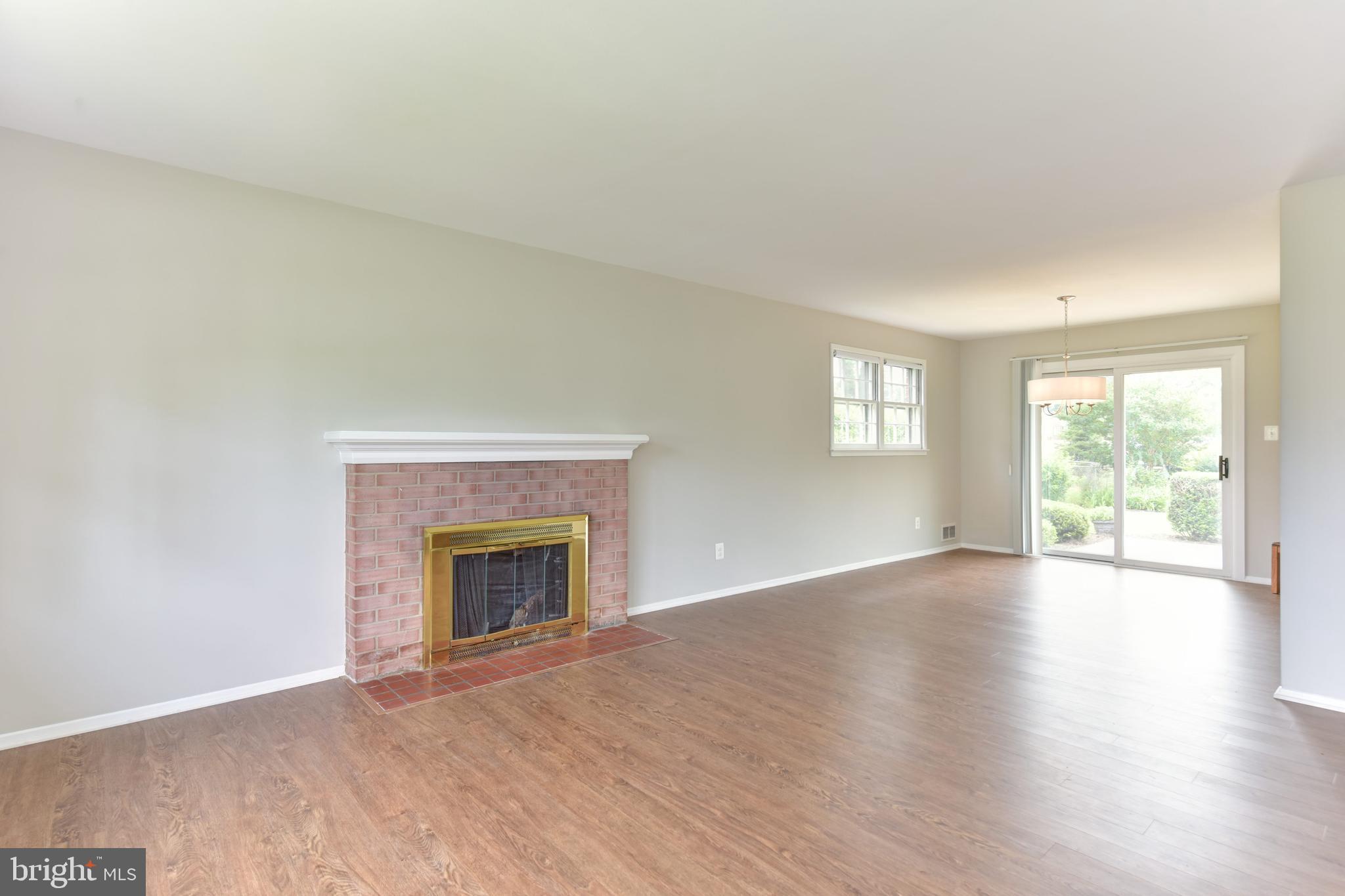8021 Ellet Road Springfield, VA 22151 - Photo 7 of 53 an empty room with wooden floor fireplace and windows