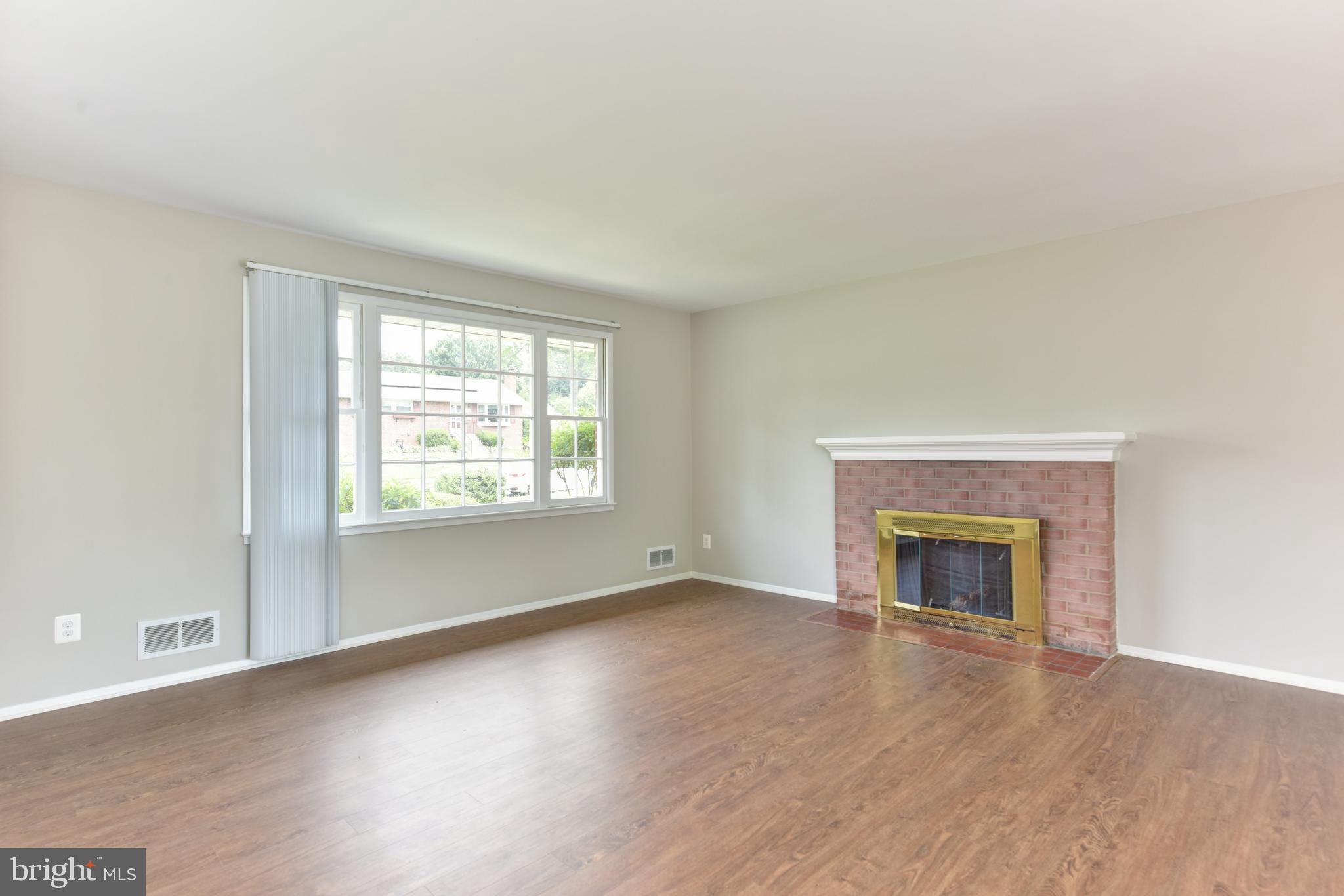 8021 Ellet Road Springfield, VA 22151 - Photo 8 of 53 an empty room with wooden floor fireplace and windows