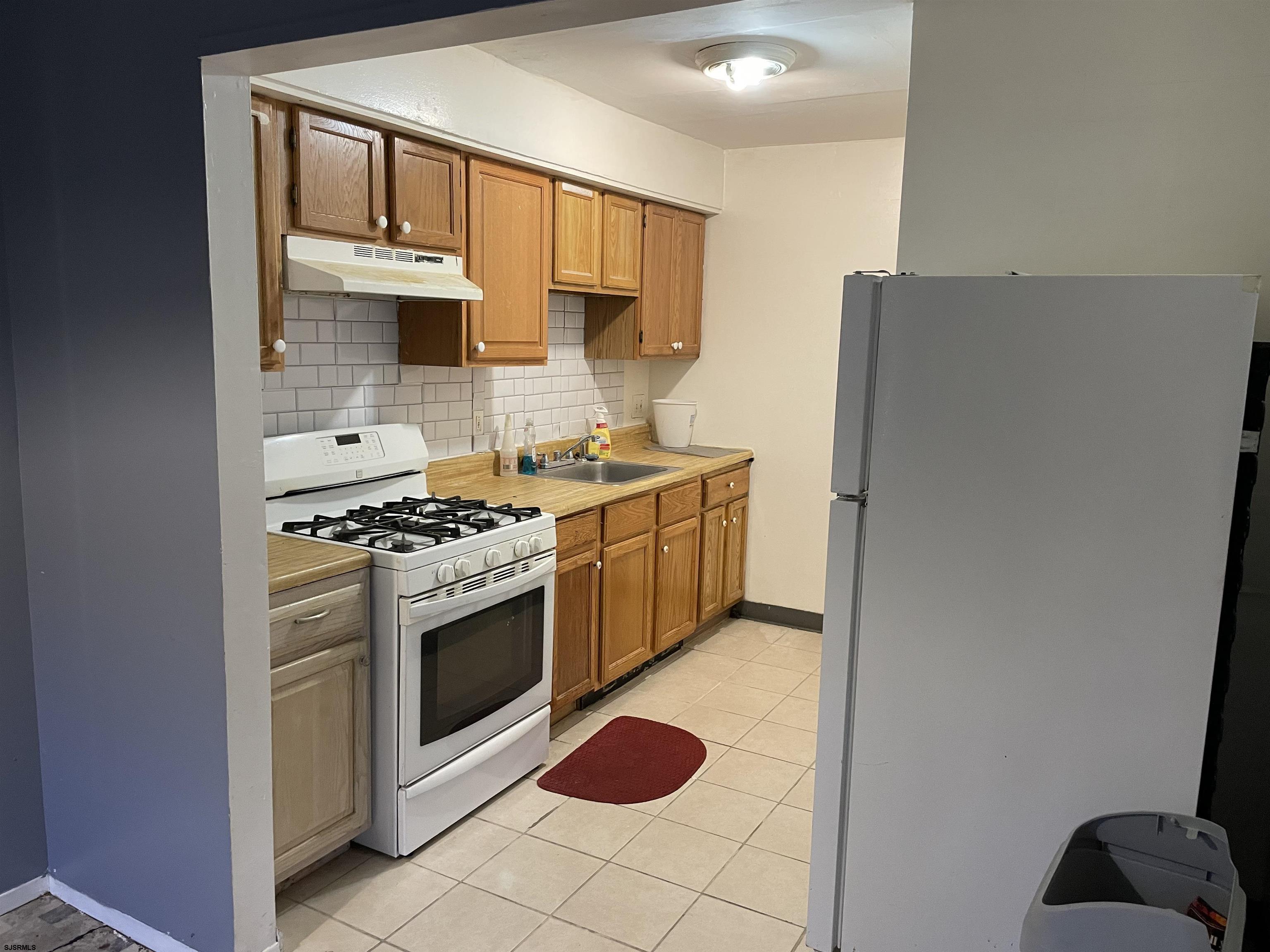 720 South New Road, Unit 5E Absecon, NJ 08201 - Photo 5 of 8 a kitchen with stainless steel appliances granite countertop a stove a sink and a refrigerator