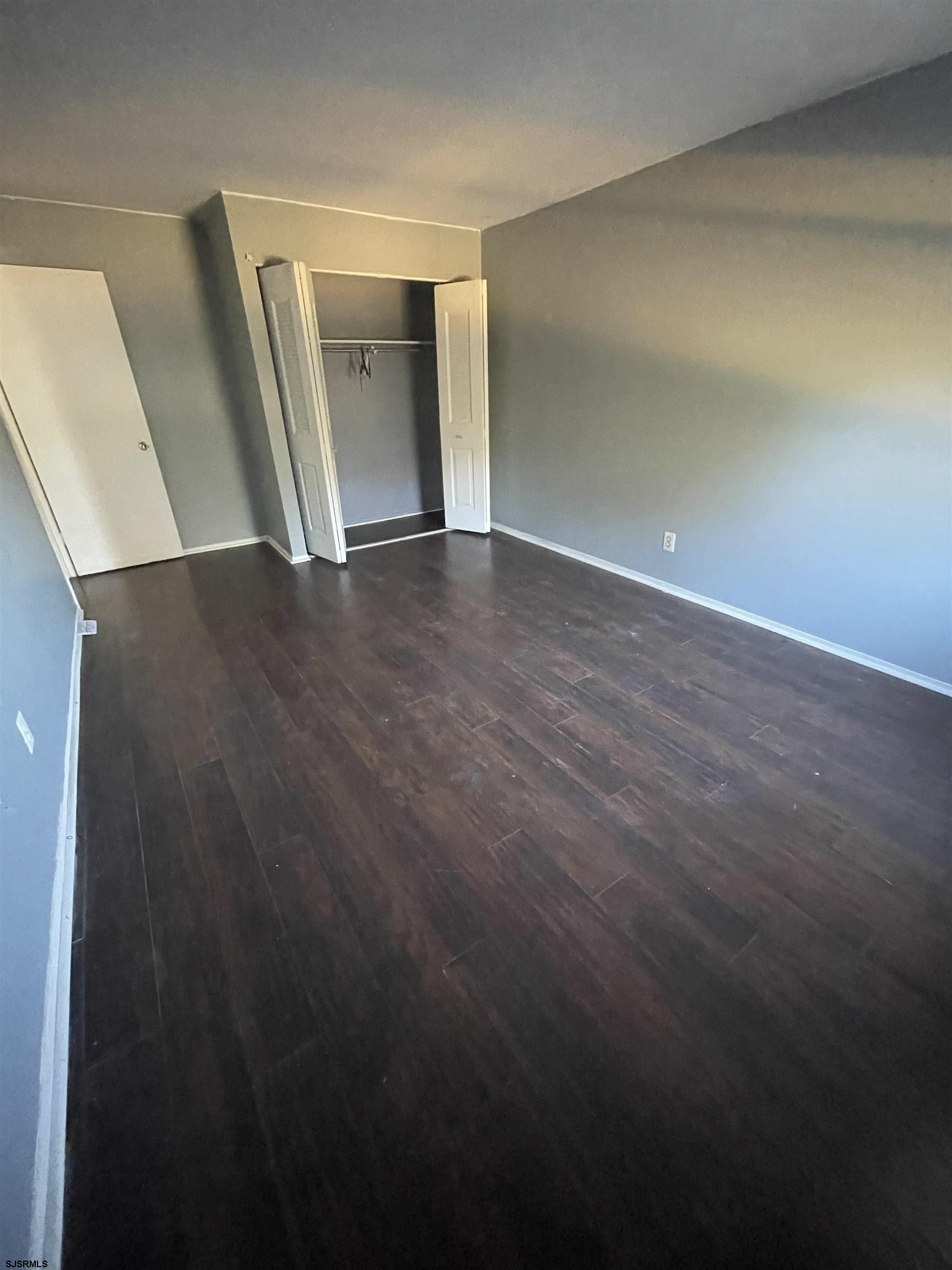 720 South New Road, Unit 5E Absecon, NJ 08201 - Photo 8 of 8 a view of an empty room with wooden floor and stairs