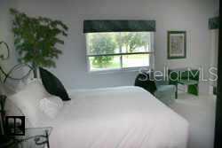 700 Starkey Road, Unit 223 Largo, FL 33771 - Photo 4 of 9 a bedroom with a bed and a potted plant
