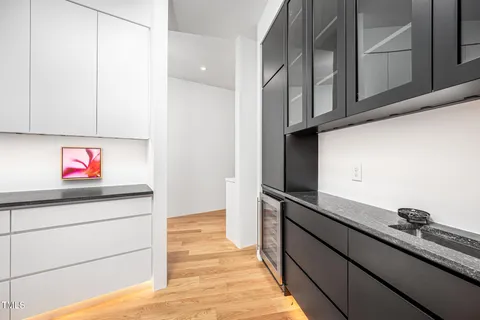 a kitchen with granite countertop white cabinets and window