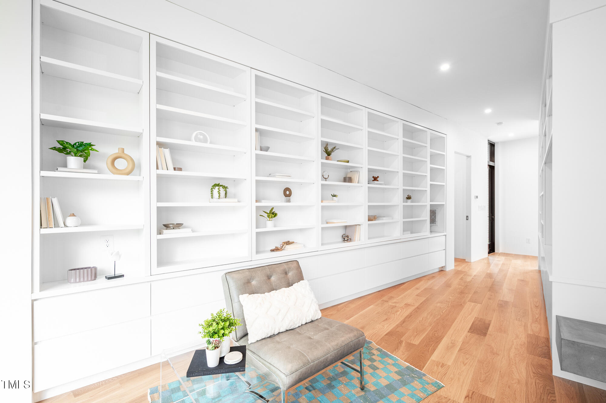 721 Jones Ferry Road Chapel Hill, NC 27516 - Photo 16 of 43 a living room with a couch and a bookshelf with wooden floor
