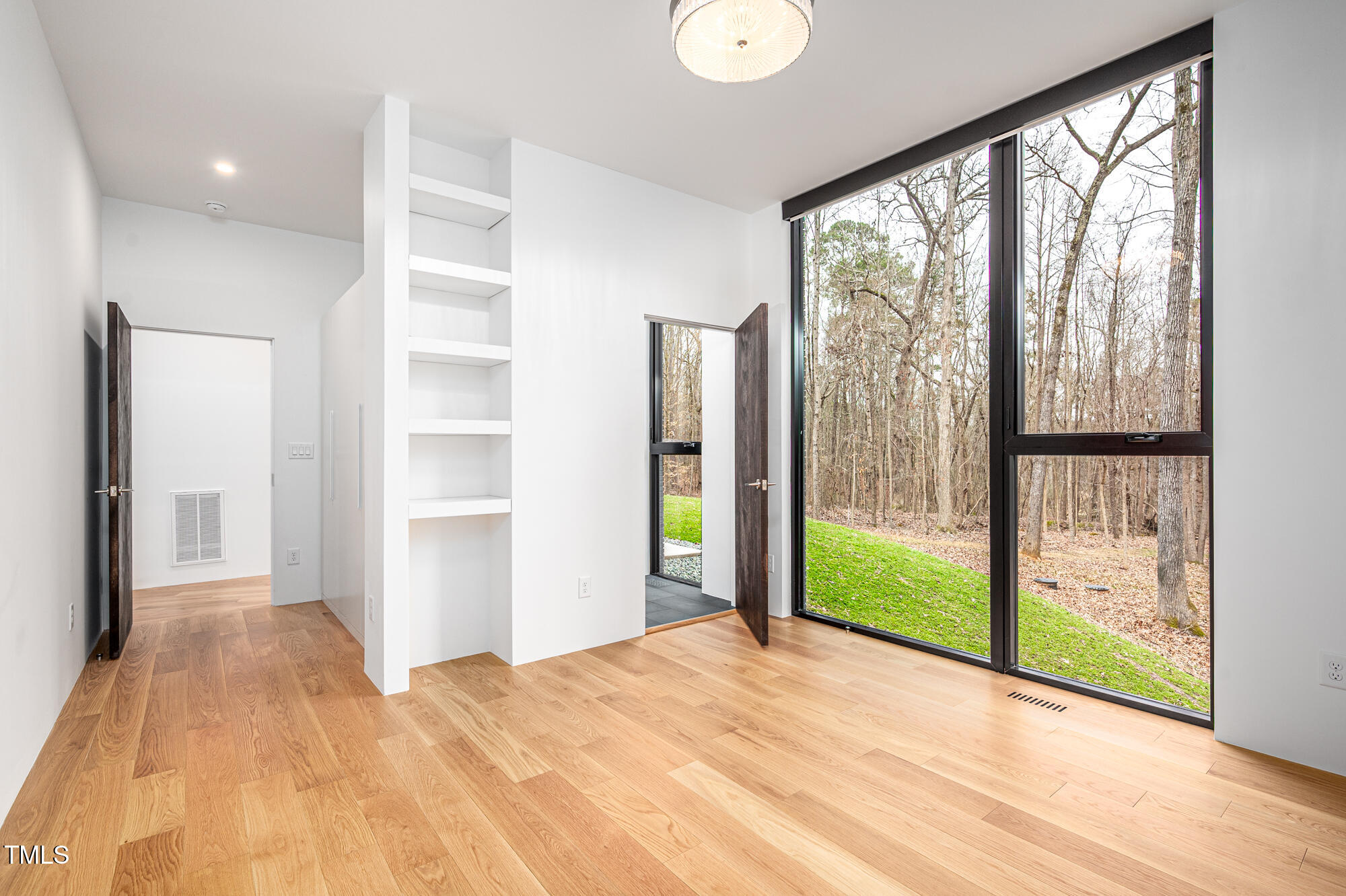 721 Jones Ferry Road Chapel Hill, NC 27516 - Photo 25 of 43 a view of an empty room with wooden floor and a window