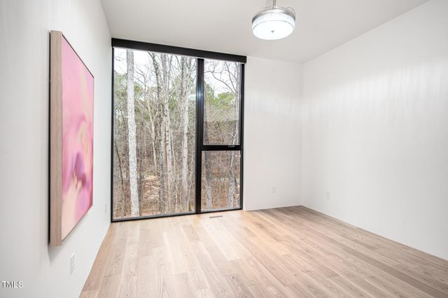 a view of a bedroom with wooden floor and bathroom