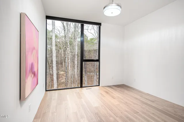 a view of a bedroom with wooden floor and bathroom
