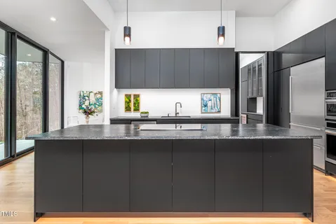 a kitchen with a sink a counter space appliances and cabinets