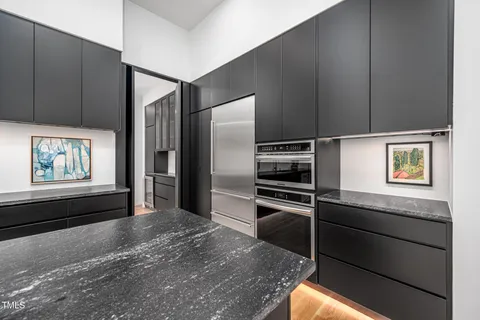 a kitchen with stainless steel appliances kitchen island granite countertop a refrigerator and a stove top oven