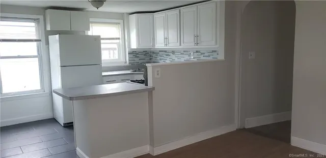a kitchen with stainless steel appliances granite countertop a sink and a refrigerator