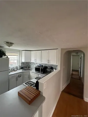 a kitchen with stainless steel appliances a stove a sink and white cabinets