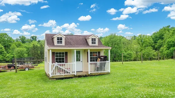 a view of a house with backyard and porch