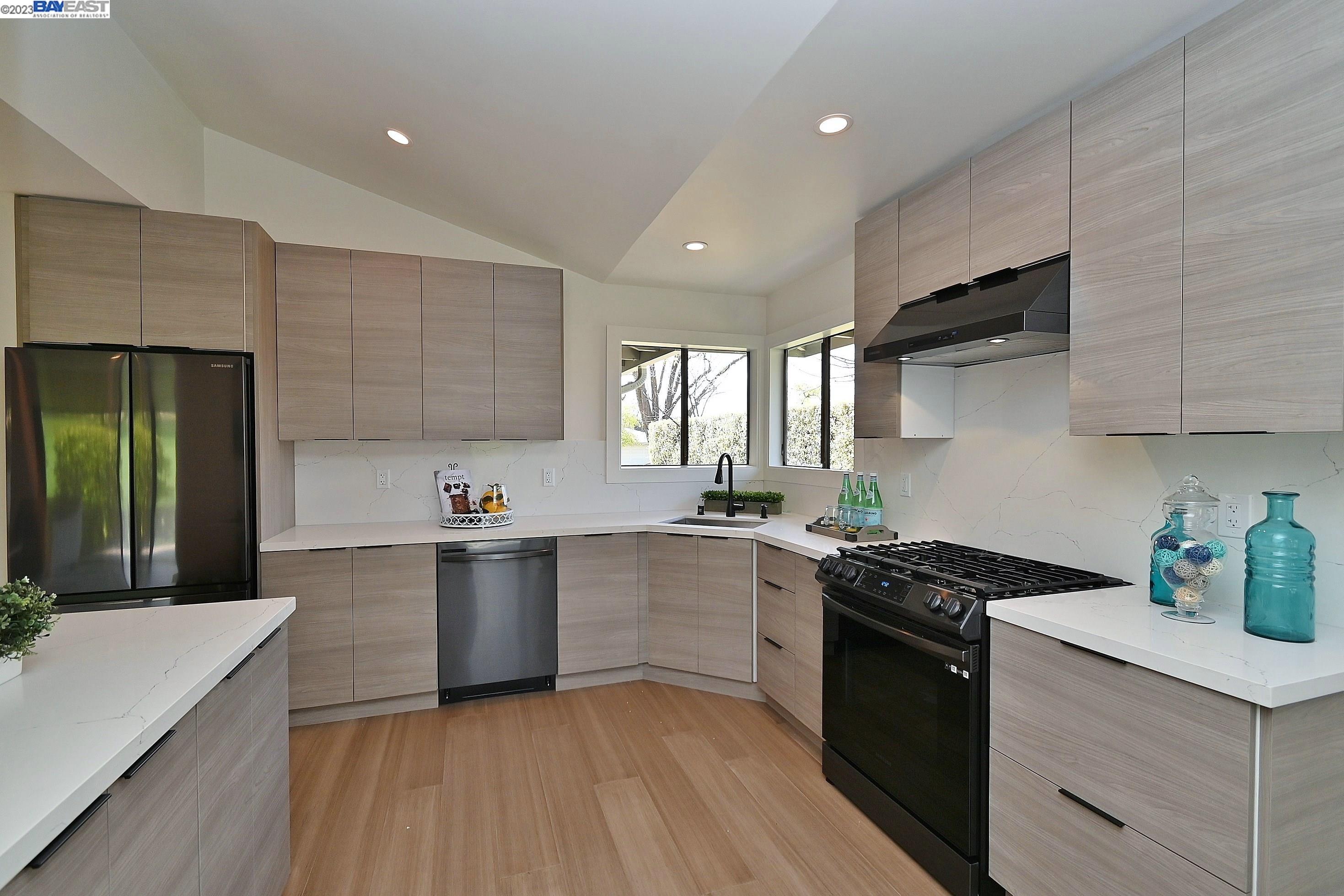 a kitchen with stainless steel appliances a sink dishwasher stove refrigerator and cabinets