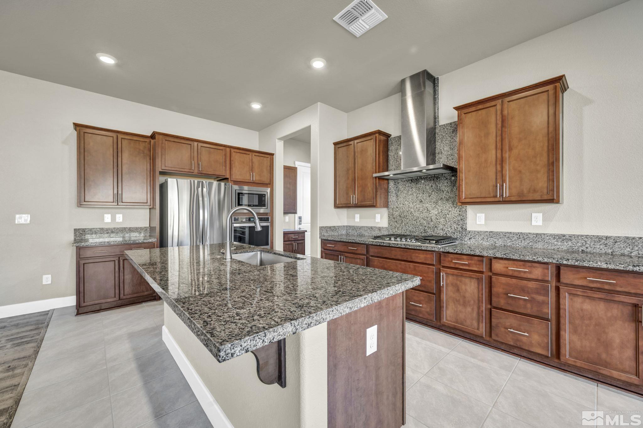 14264 Silver Moon Court Reno, NV 89521 - Photo 11 of 39 a kitchen with stainless steel appliances granite countertop a sink refrigerator and cabinets