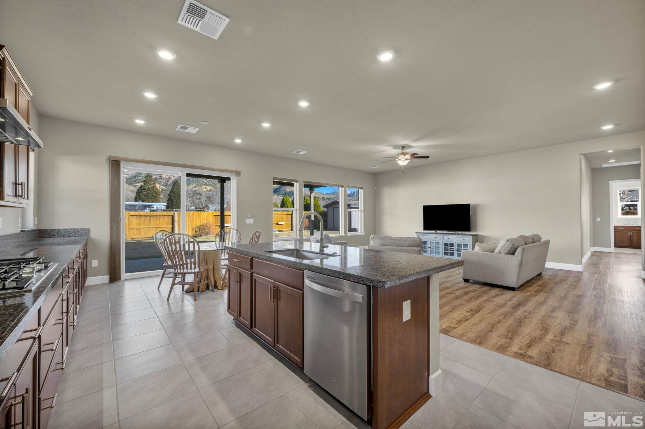 14264 Silver Moon Court Reno, NV 89521 - Photo 10 of 39 a kitchen with stainless steel appliances granite countertop a stove and a view of living room