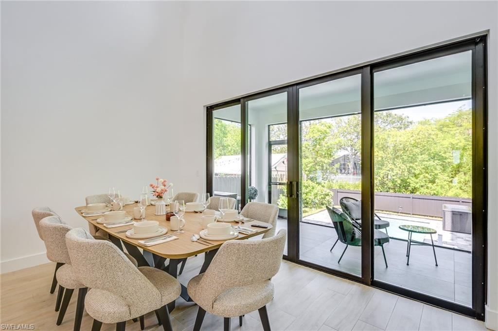 3400 Canal Street Naples, FL 34112 - Photo 16 of 28 Dining room with light wood-style flooring and a towering ceiling
