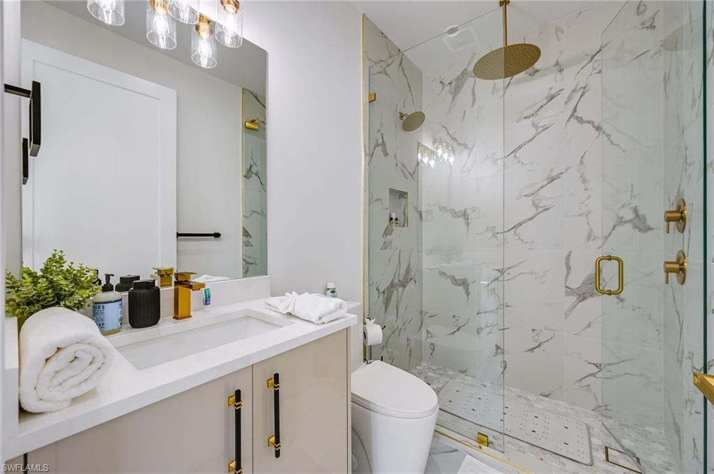 3400 Canal Street Naples, FL 34112 - Photo 26 of 28 Full bathroom with vanity, a marble finish shower, and marble finish flooring