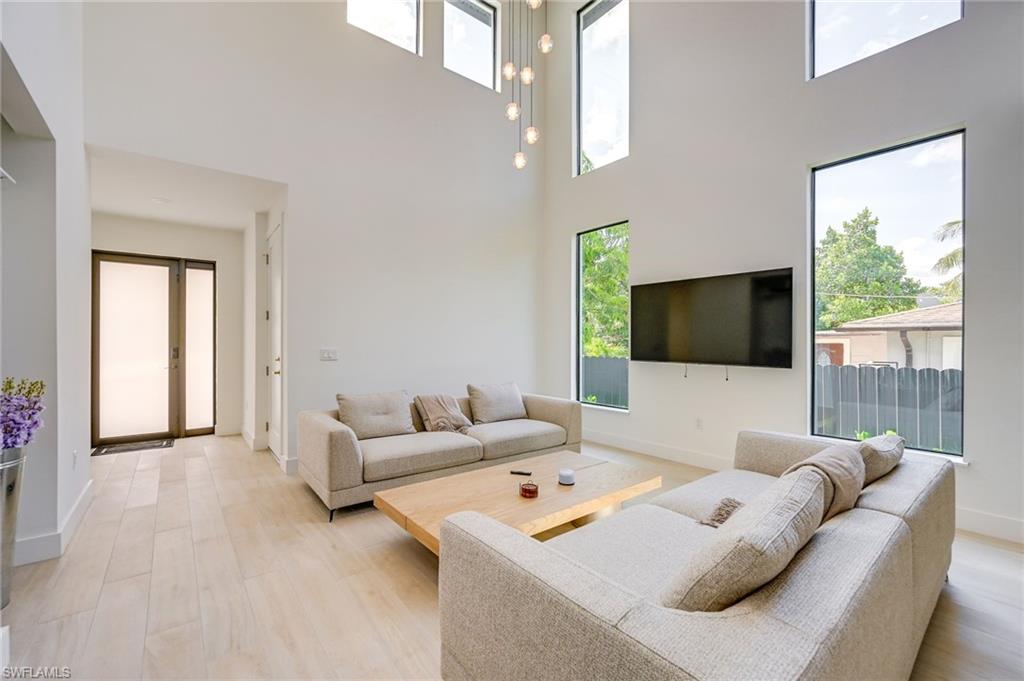 3400 Canal Street Naples, FL 34112 - Photo 3 of 28 Living area featuring a towering ceiling and light wood-style floors