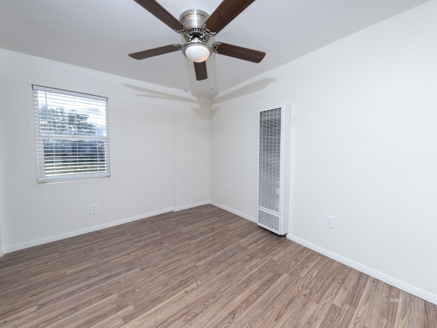 419 West Haloid Avenue Ridgecrest, CA 93555 - Photo 18 of 29 an empty room with wooden floor ceiling fan and windows