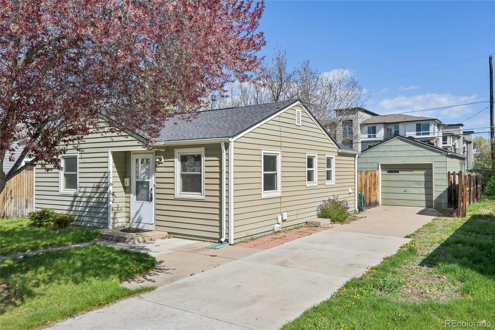 6819 Reno Drive Arvada, CO 80002 - Photo 7 of 32 a front view of a house with a yard and garage