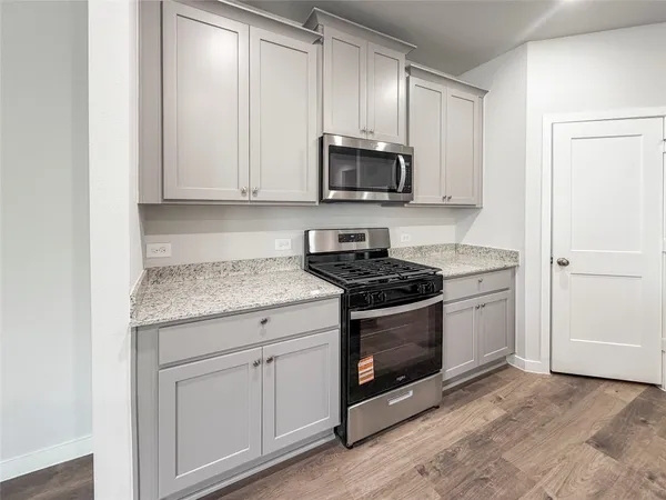 a kitchen with stainless steel appliances granite countertop a stove a microwave and cabinets