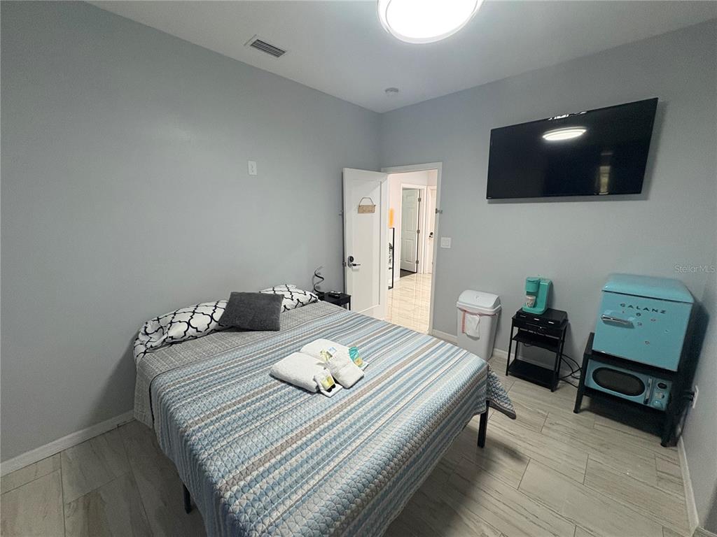 3715 Valley Tree Drive Tampa, FL 33610 - Photo 17 of 26 a bedroom with a bed and a flat screen tv