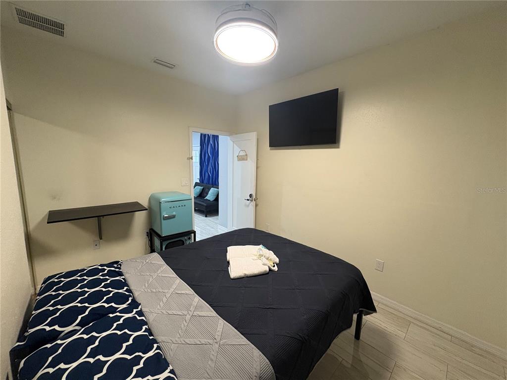 3715 Valley Tree Drive Tampa, FL 33610 - Photo 19 of 26 a bedroom with a bed and a flat tv screen on the dresser